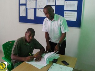 Kiungo mbrazil Emerson De Oliviera Neves Roque (kushoto) akisaini mkataba leo wa kuitumikia klabu ya Young Africans, kulia ni Afisa Habari wa klabu Baraka Kizuguto